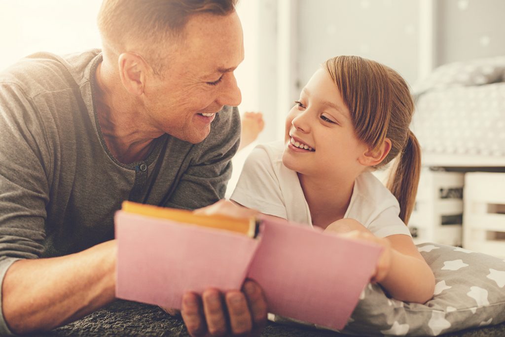 Man reading with happy daughter