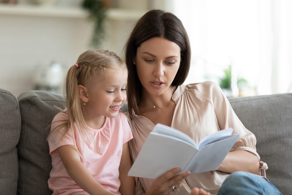 Mother with tween daughter reading book