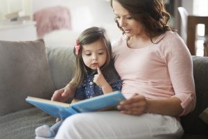 Mum and 18 month old daughter reading book